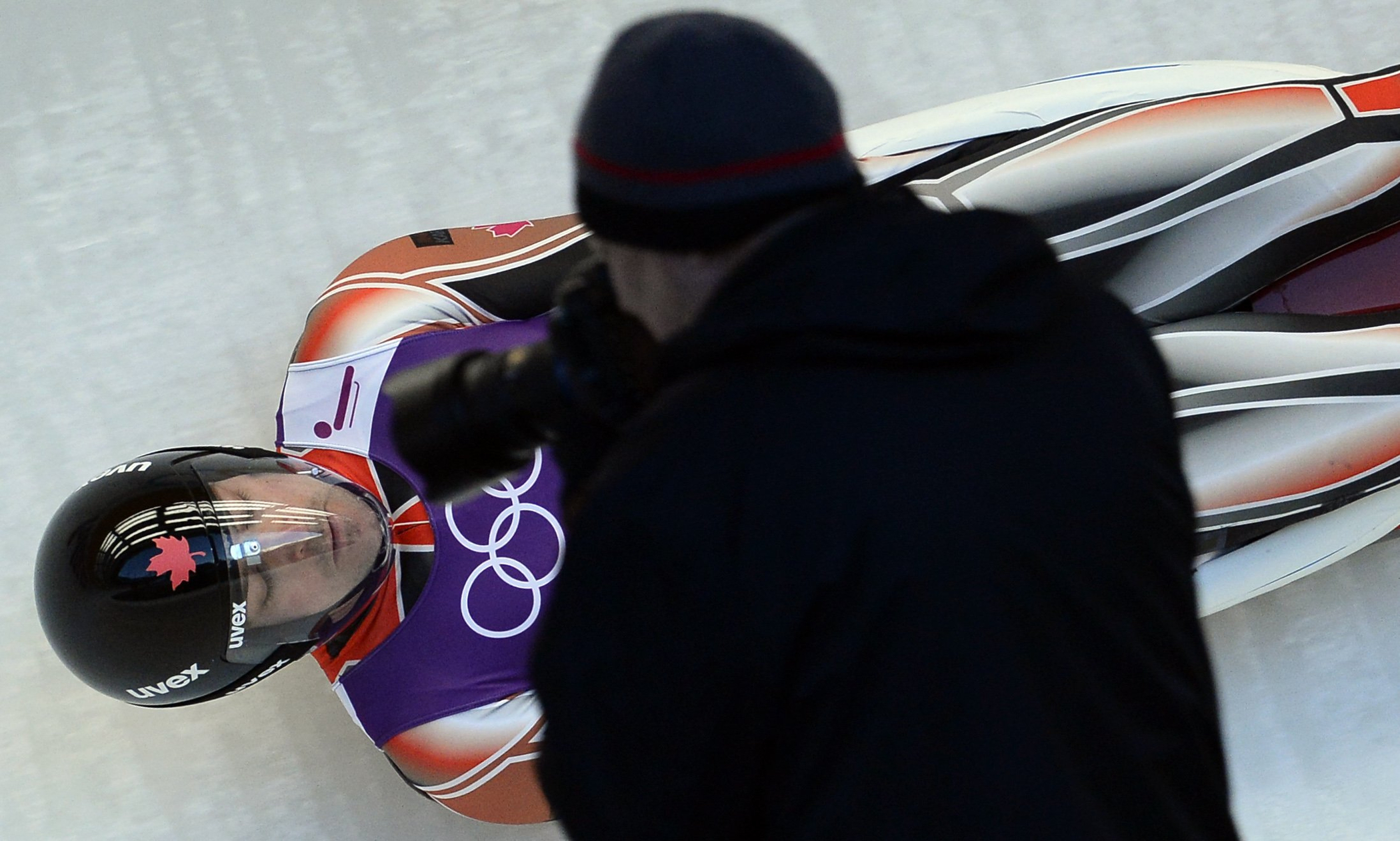 A photographer shoots an image of Canada's Sam Edney during a practices run at the men's Luge training session at the Sanki Sliding Centre in Rosa Khutor on Feb. 6, 2014, on the eve of the Sochi 2014 Olympic opening ceremony.
