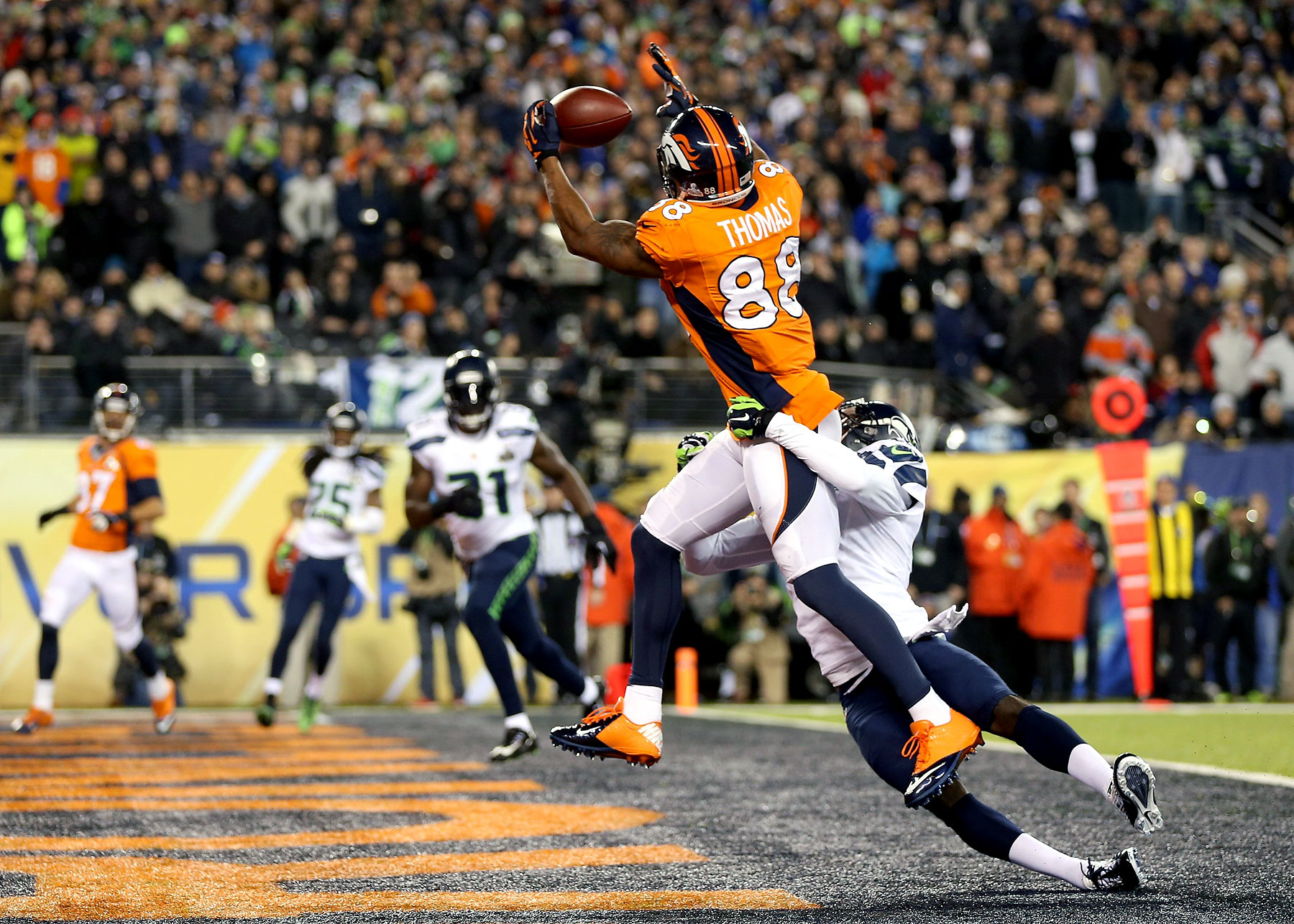 Wide receiver Demaryius Thomas of the Denver Broncos ran 14 yards to score a touchdown in the third quarter against cornerback Byron Maxwel of the Seattle Seahawks.