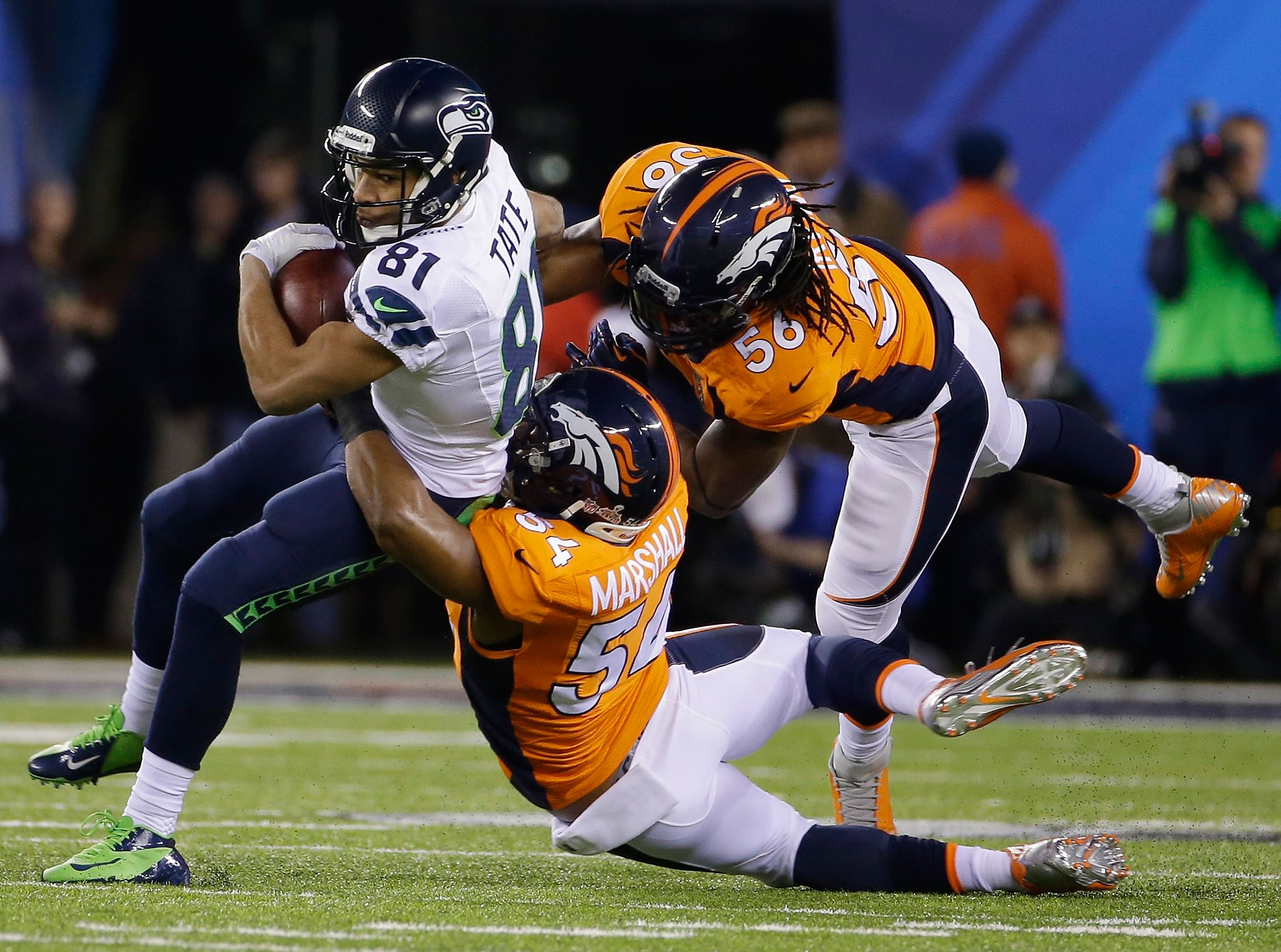 Seattle Seahawks' Golden Tate is tackled by Denver Broncos' Brandon Marshall and Nate Irving during the first quarter.
