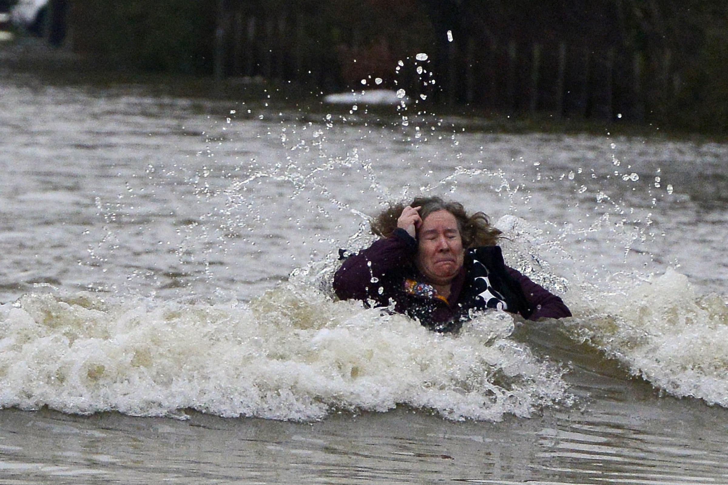 A woman becomes caught up in a lorries wash during flooding, Feb. 10, 2014, in Old Windsor in Berkshire after the River Thames burst its banks.