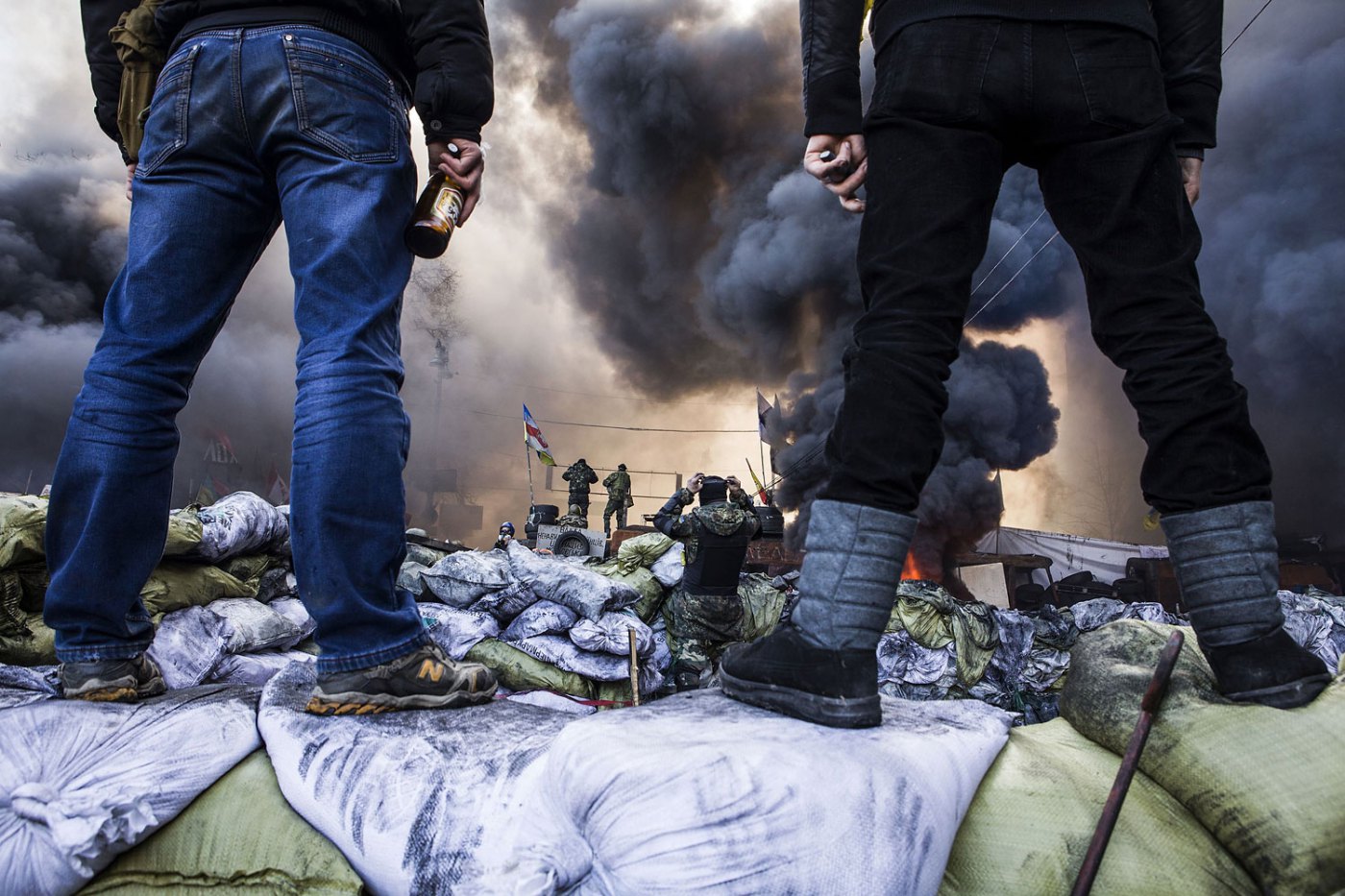 Anti-government demonstrators stand on barricades during clashes with riot police, Feb. 18, 2014.