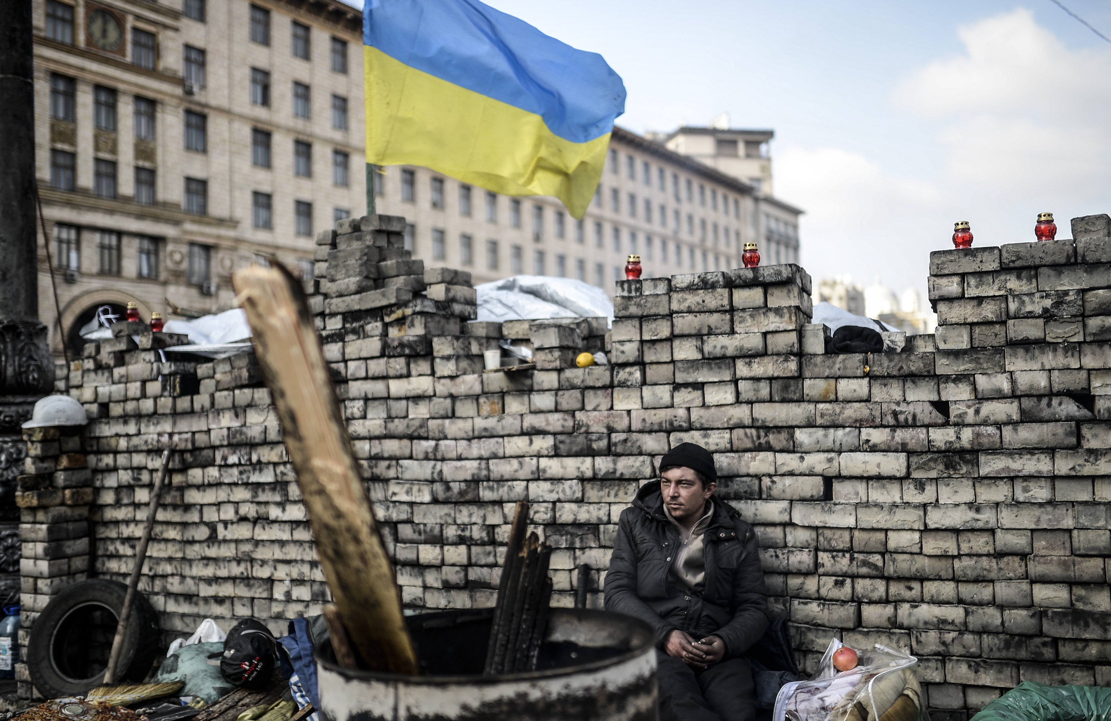 An anti-government protester sits behind a barricade on Kiev's Independence Square on February 24, 2014.