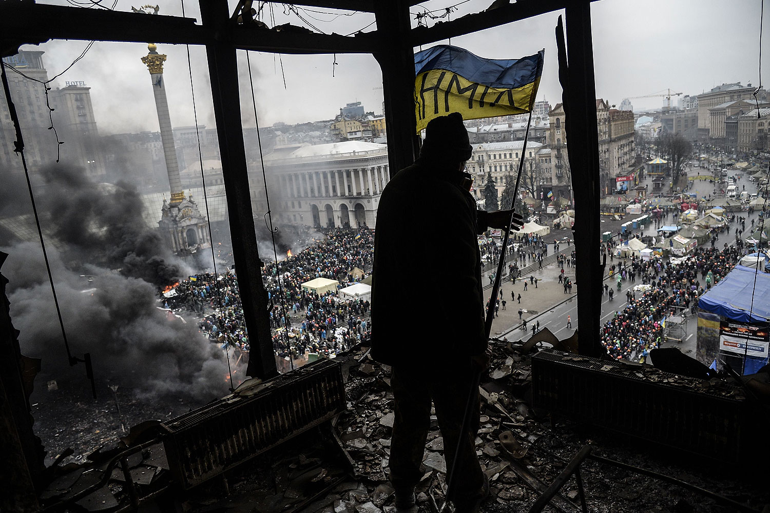 A demonstrator stands on a balcony overlooking Independence square in Kiev, Feb. 20, 2014 (Bulent Kilic / AFP / Getty Images)