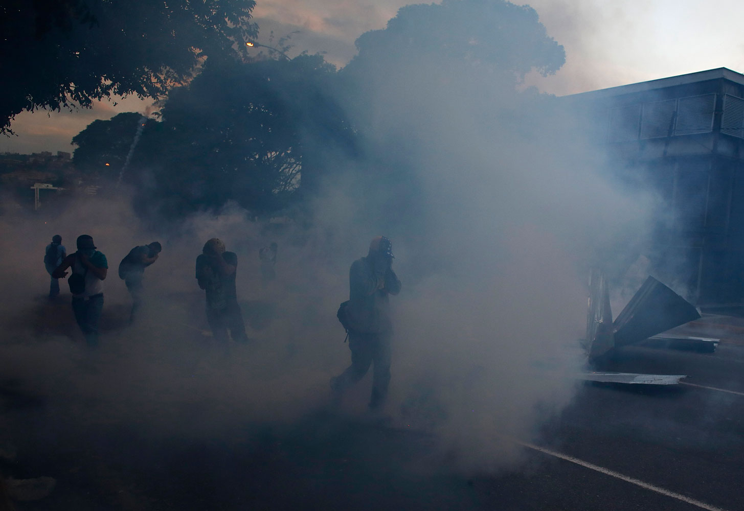Anti-government protesters run away from tear gas during clashes with the national guard at Altamira square in Caracas, Feb. 28, 2014.