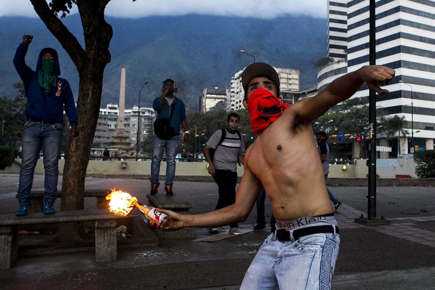 A demonstrator throws an incendiary device during clashes with Venezuelan National Bolivarian Guard during a protest against president Nicolas Maduro in Caracas, Venezuela, Feb. 27, 2014.
