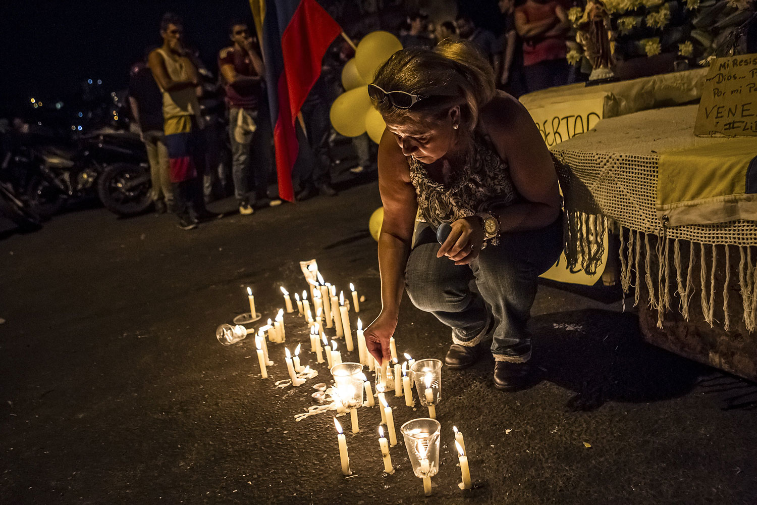 Community members hold mass to pray for the end to violence against protesters in a barricaded area in San Cristobal, Feb. 23, 2014.
