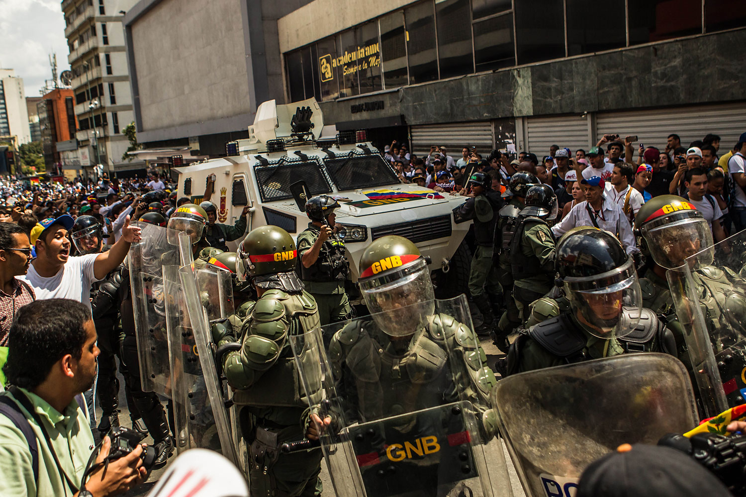 Riot police guard the armored vehicle with Leopoldo Lopez inside, in Caracas, Feb. 18, 2014.