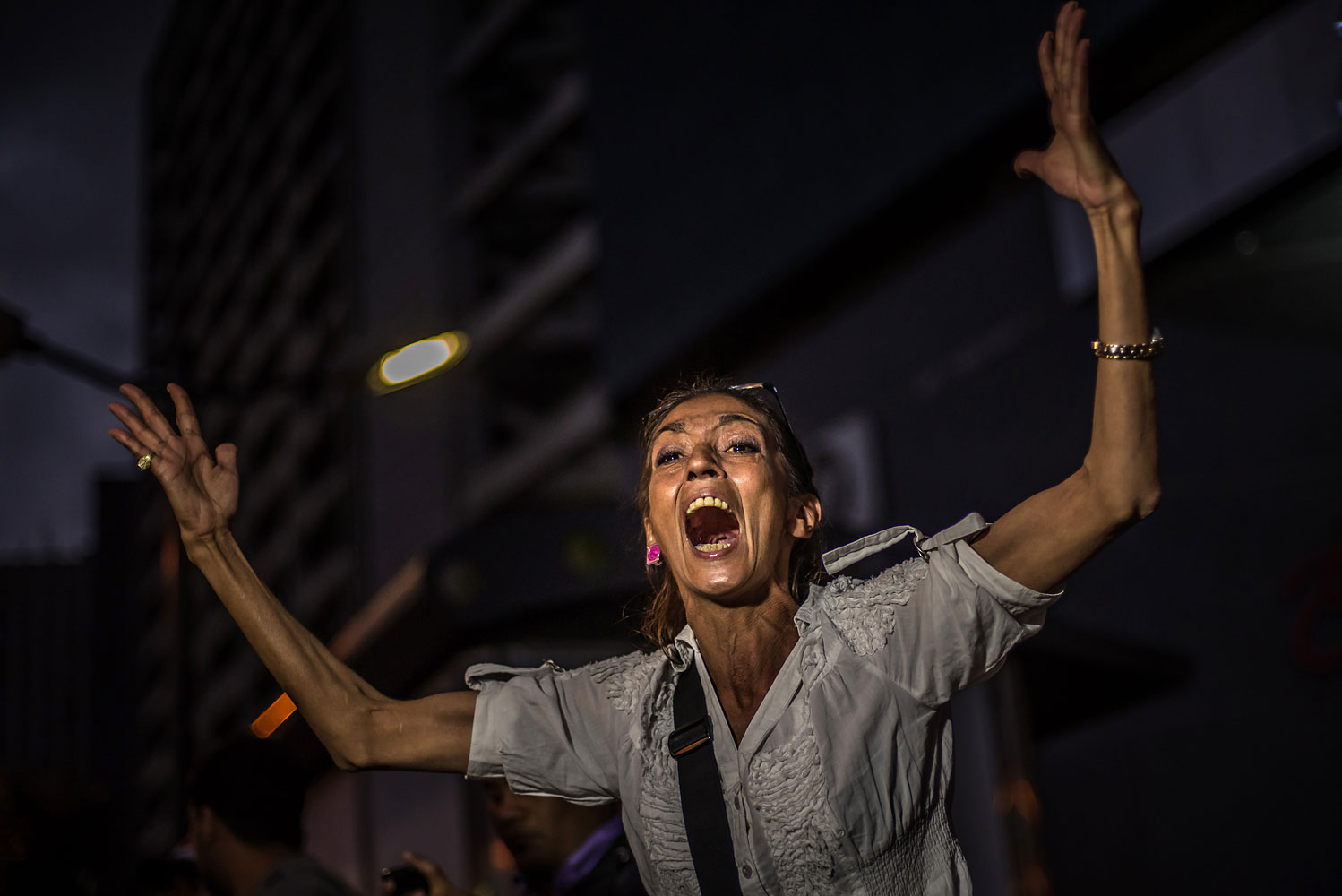 A mother yells at the riot police during a student protest against the Venezuelan government, in Caracas, Feb. 17, 2014.