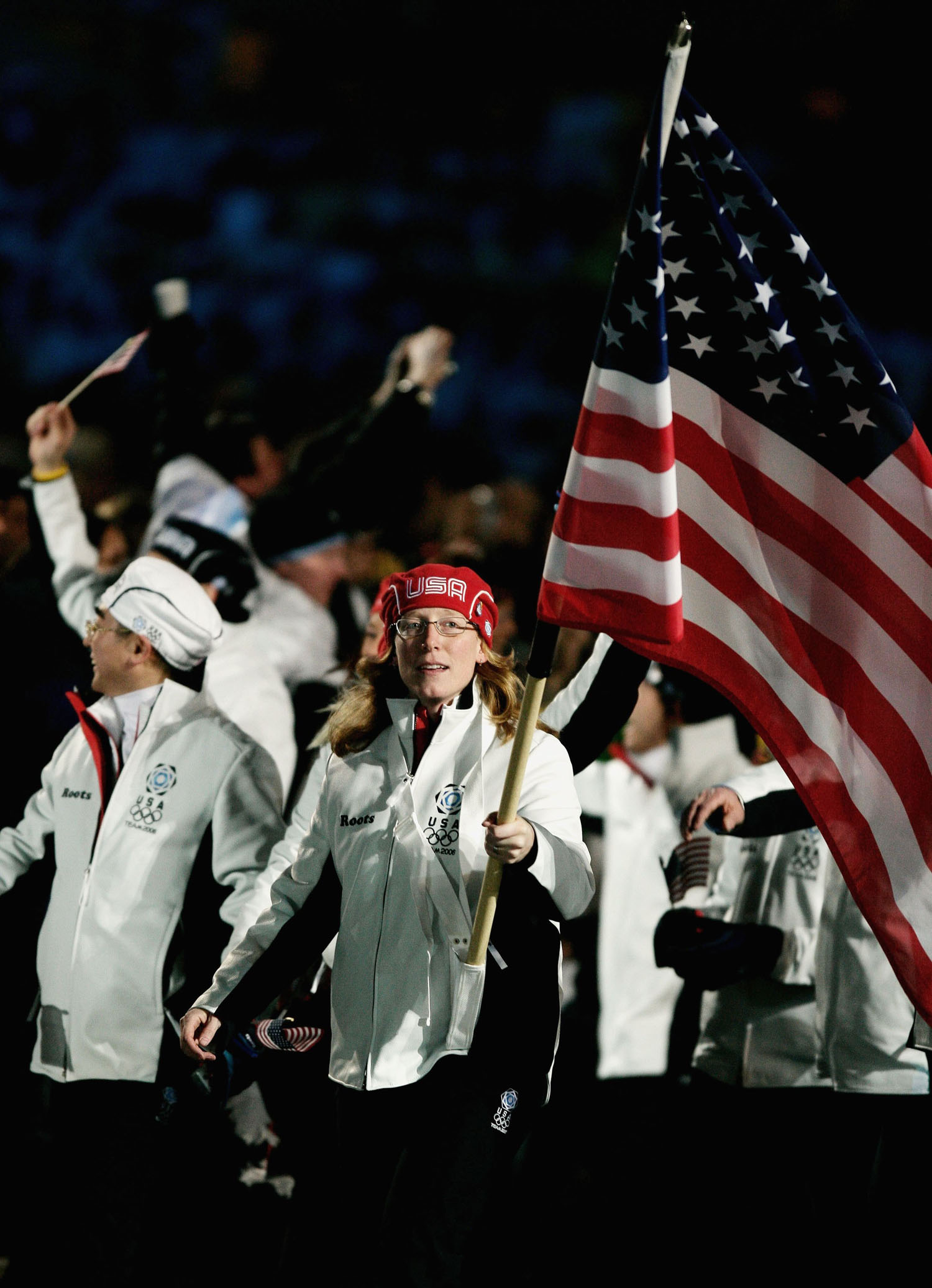 Speed skater Chris Witty carries the US flag as she and her teammates attend the opening ceremony of the Turin Winter Olympic Games on Feb. 10, 2006.