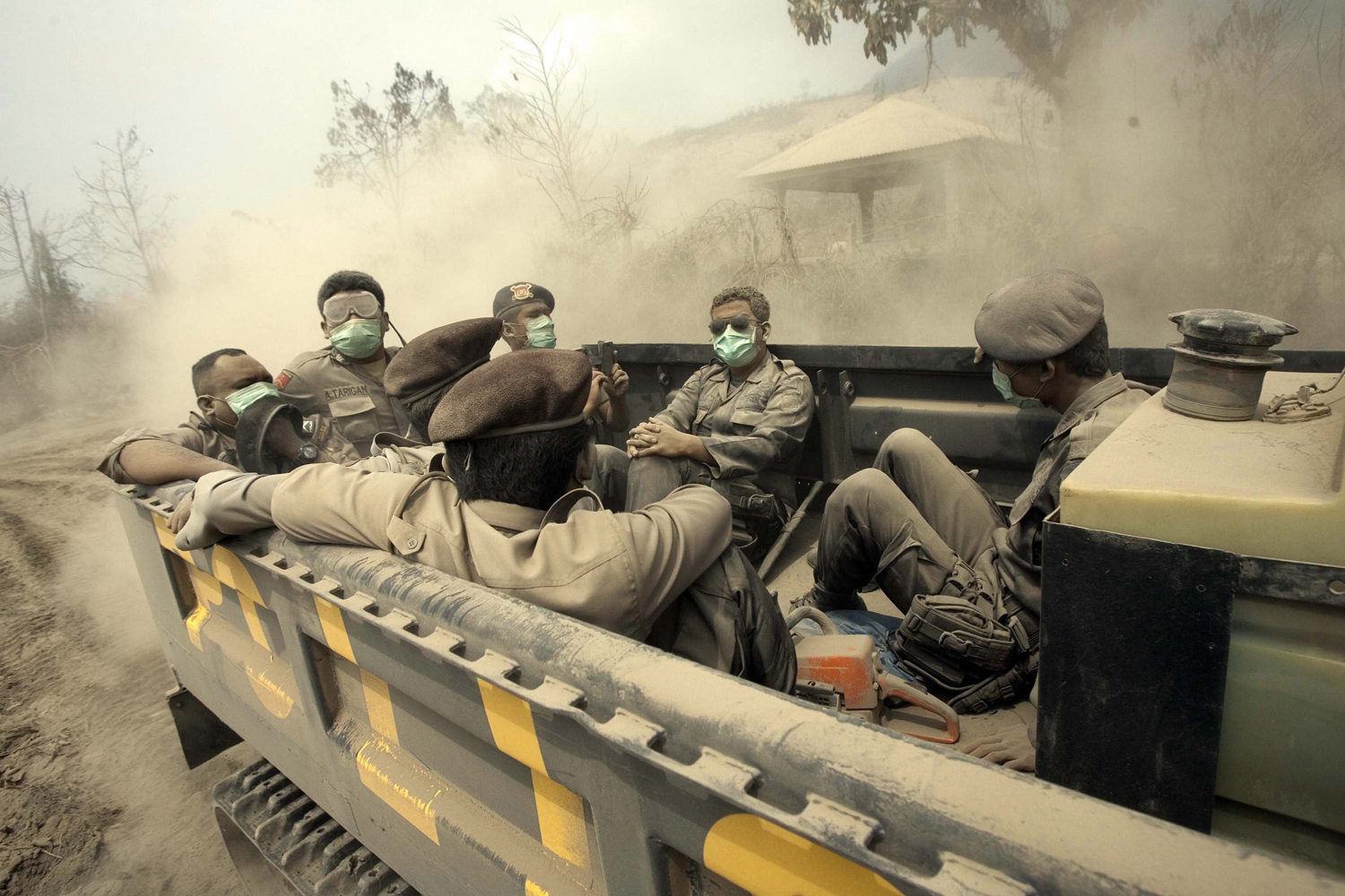 Feb. 2, 2014. Indonesian policemen sit on an utility  vehicle as they search for victims of  Mount Sinabung eruption in Karo, North Sumatra, Indonesia.