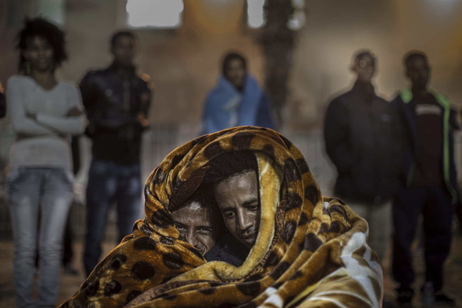 Feb. 3, 2014. African asylum seekers share a blanket to keep warm while attending a protest in Levinski Park, southern Tel Aviv, Israel.