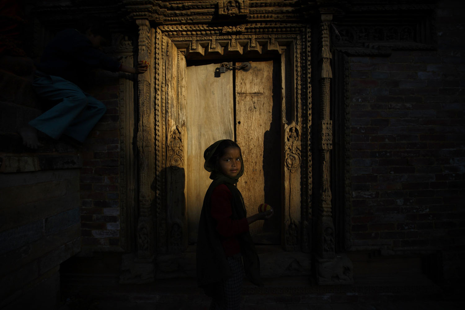 Feb. 3, 2014. Evening light illuminates a girl playing at the Patan Durbar Square in Lalitpur, Nepal.
