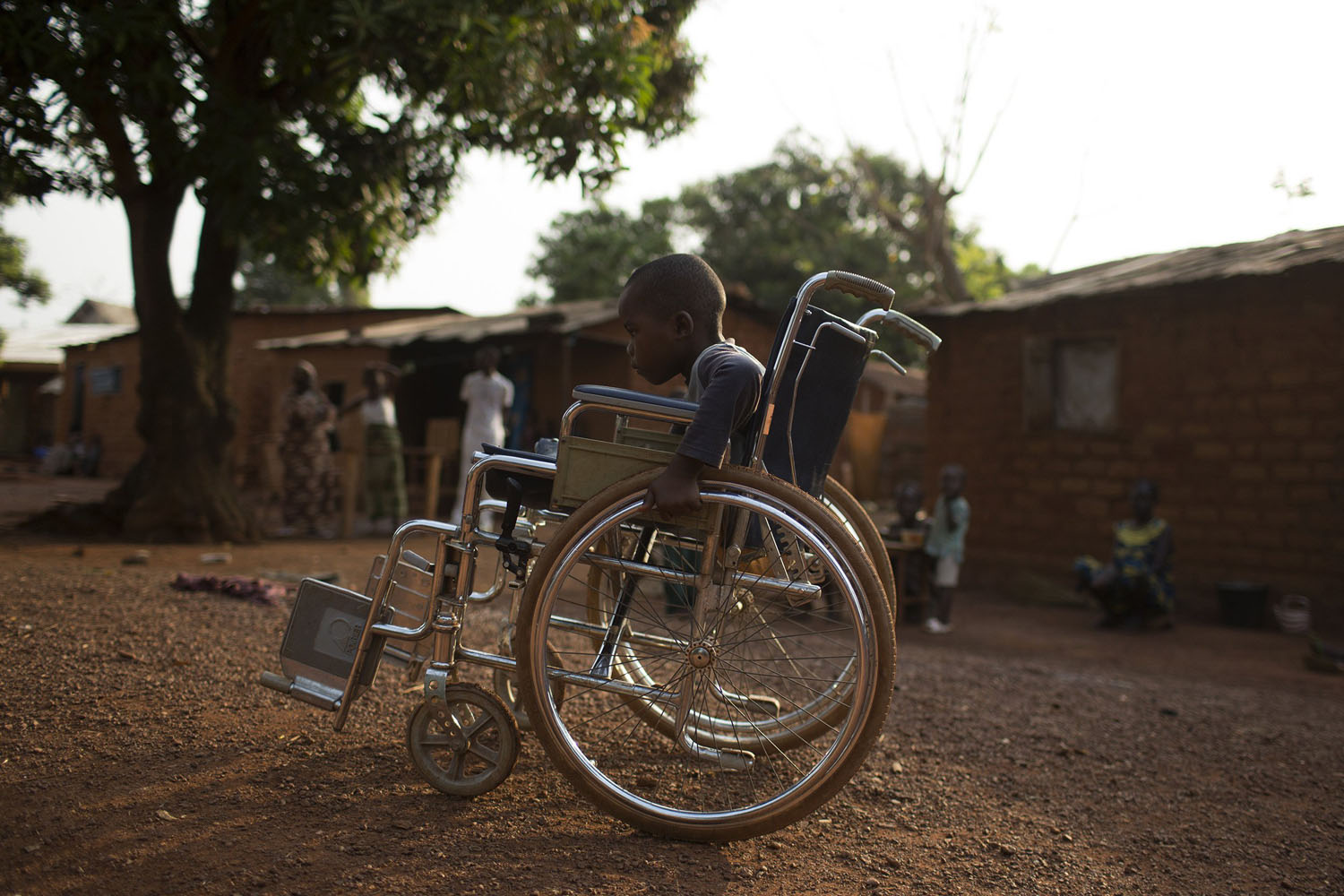 Mougounou pushes his wheel chair close to his home in the district of Boy Rabe in the capital Bangui