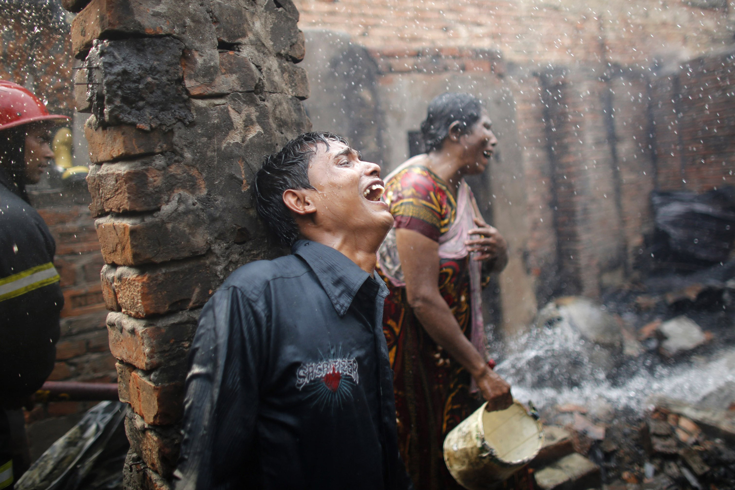 Feb. 11, 2014. People cry after losing all of their belongings in a fire at a slum at Mirpur in Dhaka.