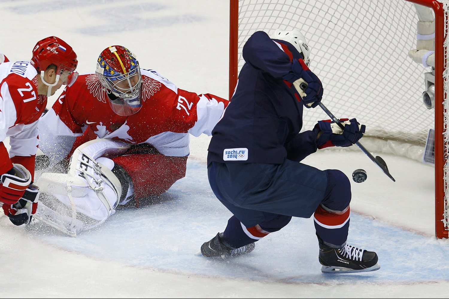Team USA's Fowler scores on Russia's goalie Bobrovski and Russia's Tereshenko during the second period of their men's preliminary round ice hockey game at the 2014 Sochi Winter Olympics