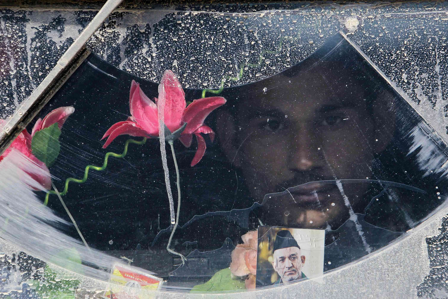 An Afghan National Army soldier looks out from the windshield of an armoured car at the Forward Base in Nari