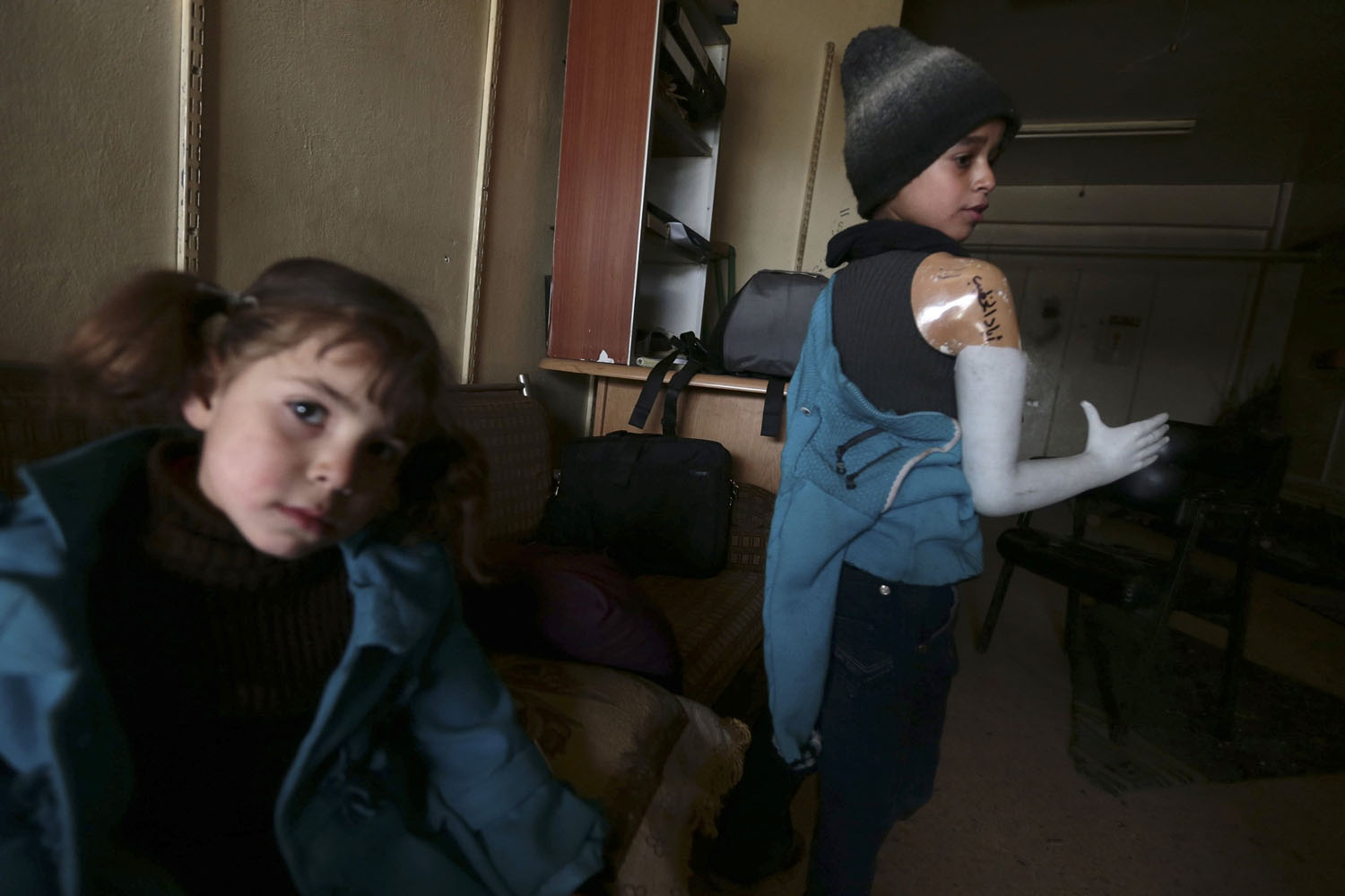 Eyad, a 12 year-old boy who lost his arm during shelling by forces loyal to Syria's President Assad, tries on a prosthetic arm in Damascus