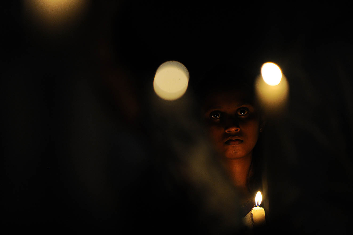 Jan. 31, 2014. Sri Lankan Central Bank employees hold candles as they attend a memorial in Colombo for the 91 people killed when Tamil Tiger separatists carried out a suicide truck-bomb attack against the Central Bank of Sri Lanka building in downtown Colombo 18 years ago.