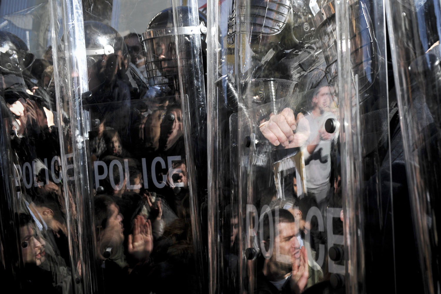 Feb. 3, 2014. Protesters shouting slogans are reflected in riot police shields as they take part in a demonstration in front of the local education authority of Pristina's University to ask for the resignation of the university's chancellor, Ibrahim Gashi, and the removal of scientific titles for professors that have published in false scientific magazines.