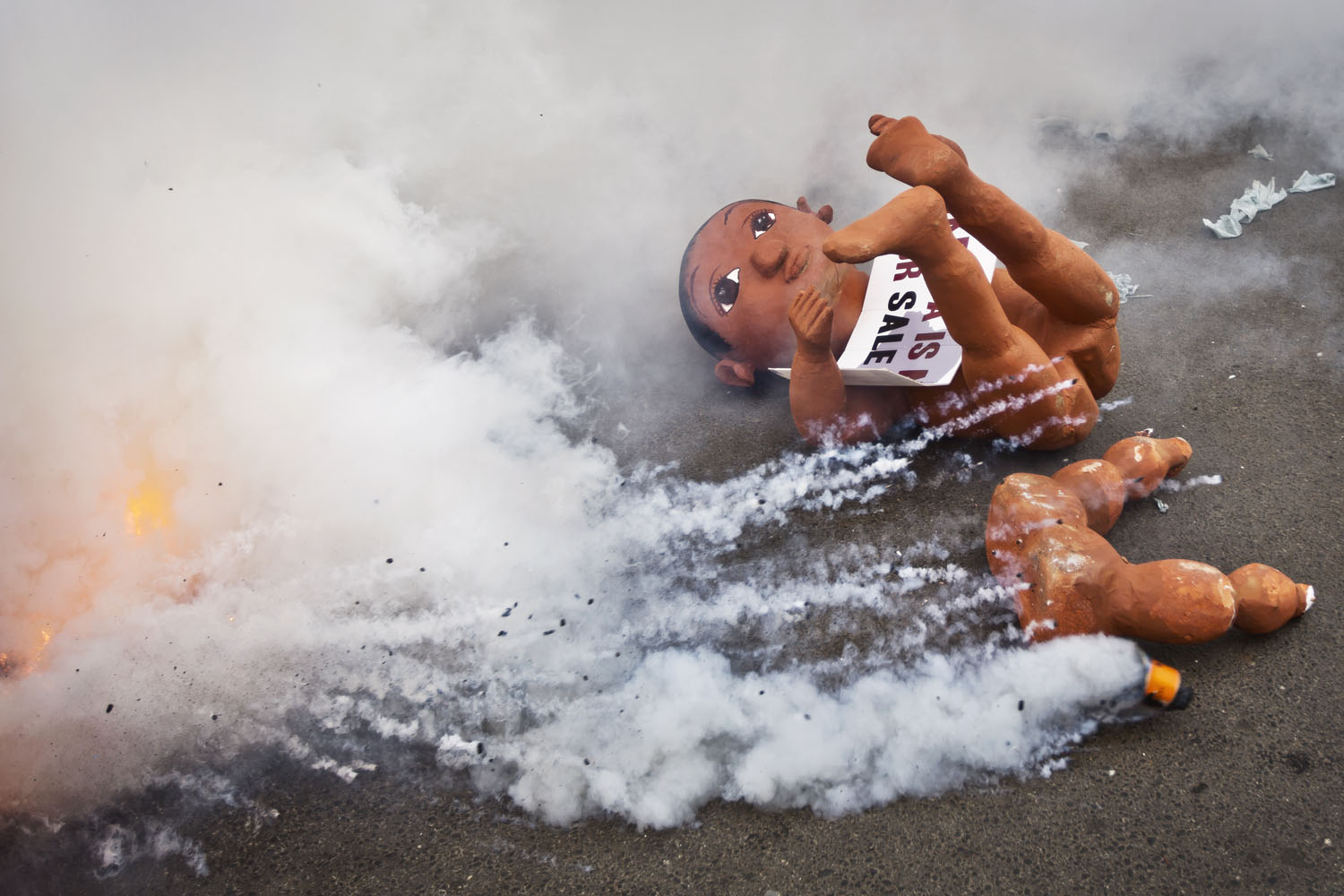 Feb. 13, 2014. A giant mock baby used by anti-government protesters to represent what they claimed was the  childish  apathy of the Kenyan people and the need for the country to  grow up , lies abandoned on the street as demonstrators flee tear gas canisters fired by police exploding around them, in downtown Nairobi, Kenya.