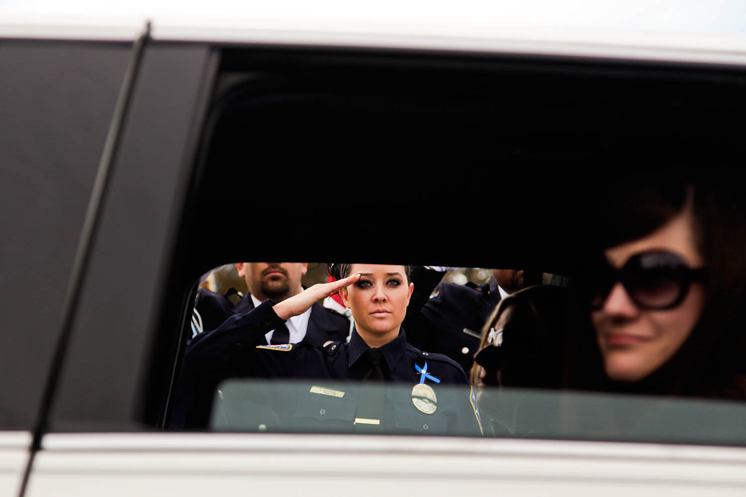 Feb. 5, 2014. A police officer, left, salutes as family members arrive before the interment ceremony for Utah County Sheriff's Sgt. Cory Wride at the Spanish Fork City Cemetery in Spanish Fork, Utah.
