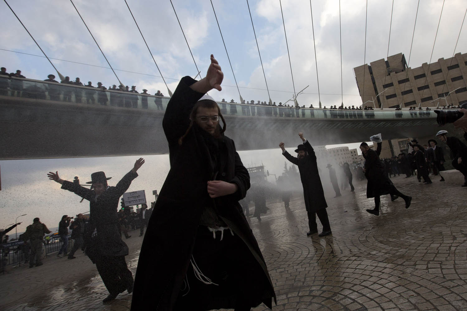 Feb. 6, 2014. Police officers shoot a water canon at ultra-Orthodox Jewish men during their demonstration in Jerusalem.