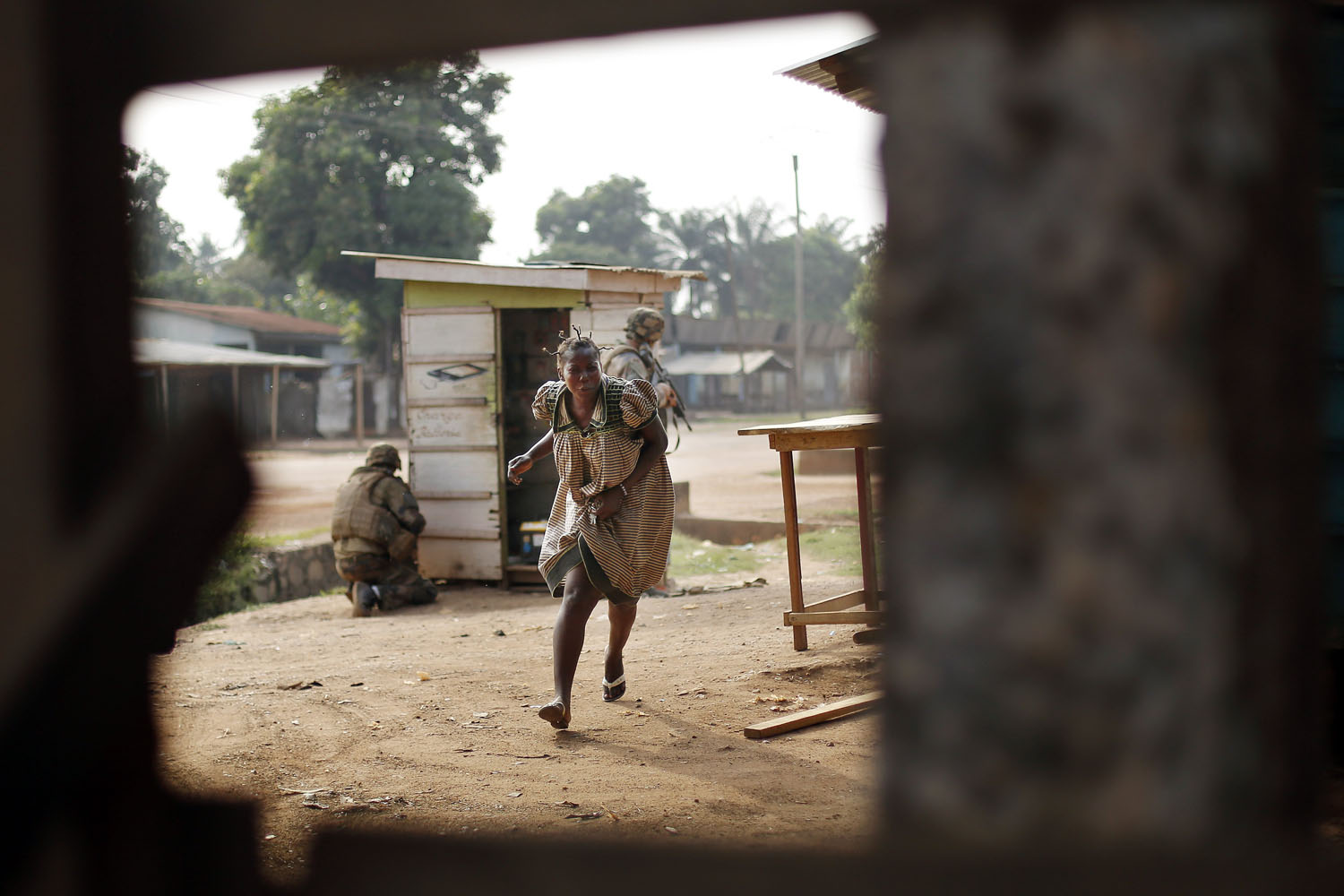 Feb. 3, 2014. A woman runs for cover as heavy gunfire erupts in the Miskin district of Bangui, Central African Republic.