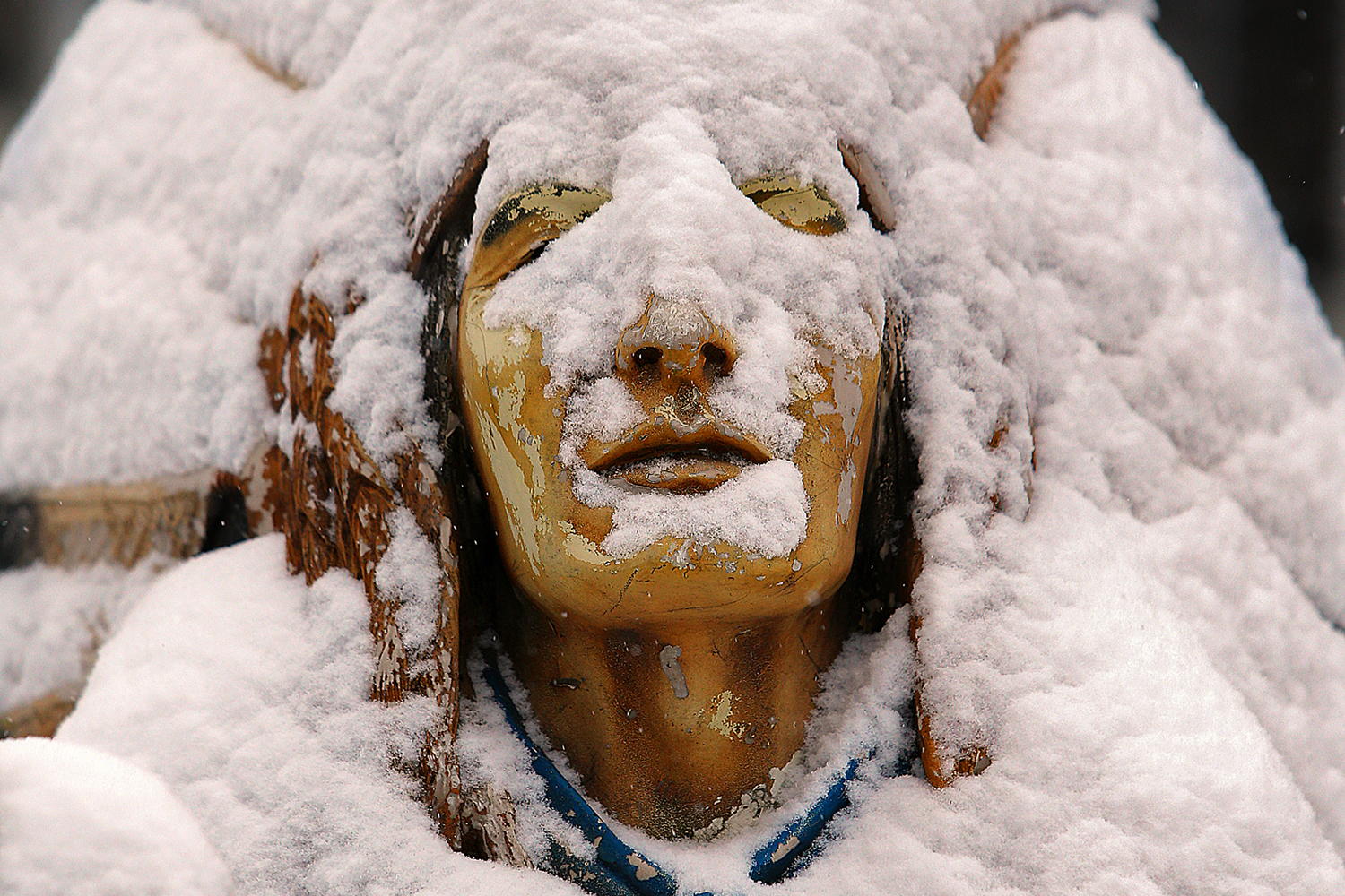 Feb. 12, 2014. The face of an Native American statue at the Chattahoochee Ruby Mine is barely visible, covered with inches of fresh snow on Main Street in Helen, Ga.