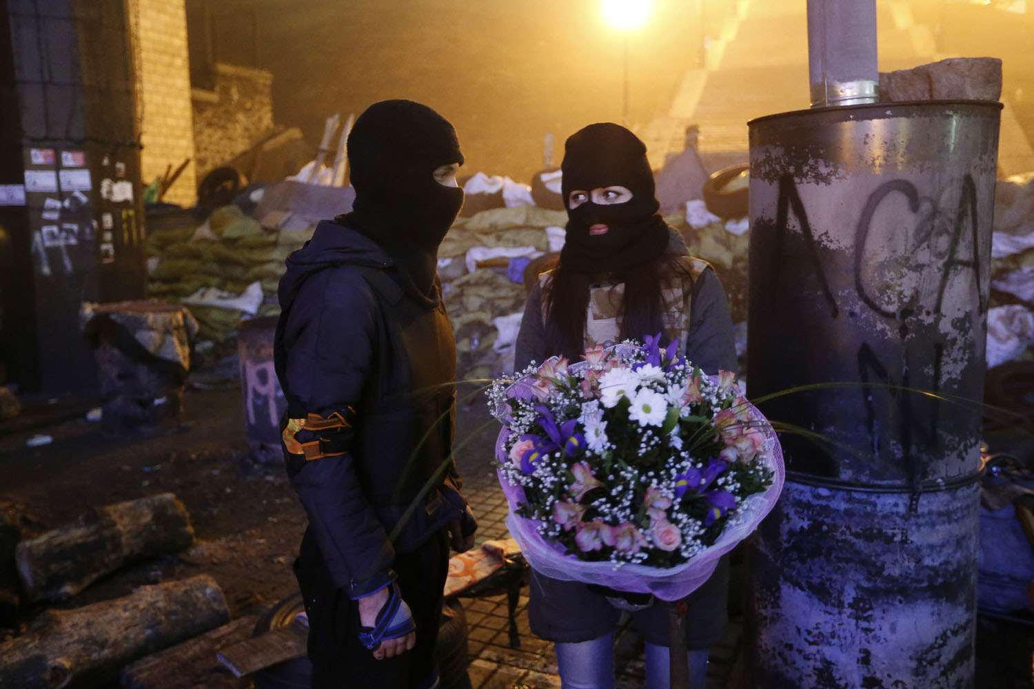 Feb. 13, 2014. An activist from the  Right Sector  anti-government protest group presents a bouquet of flowers to his girlfriend in front of fellow activists near the site of previous clashes with riot police in Kiev, Ukraine.