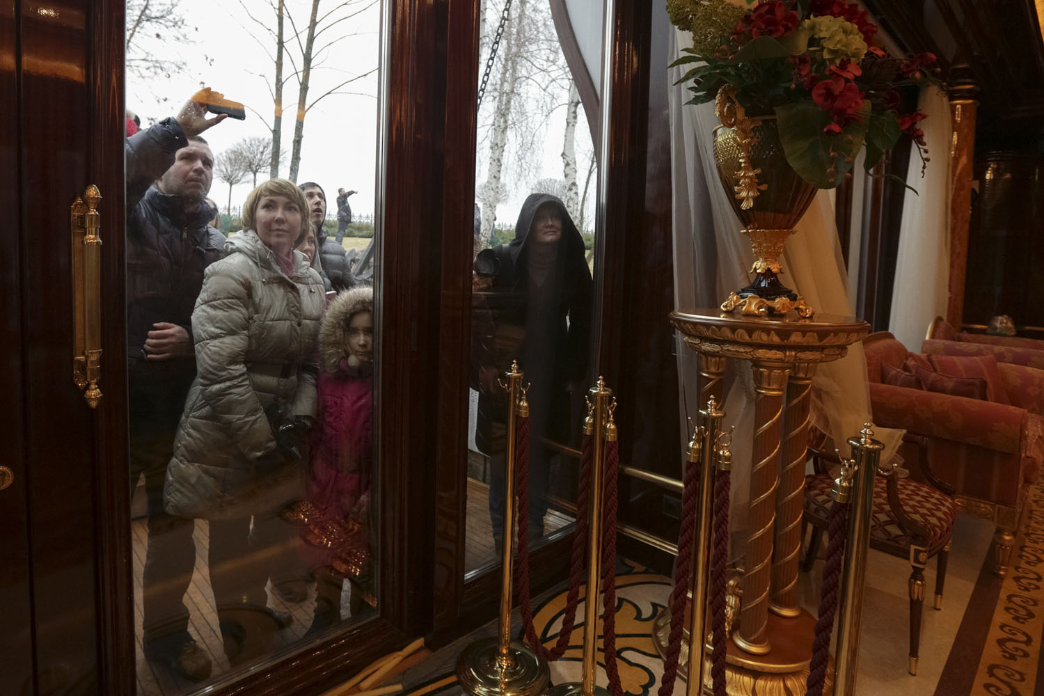 People look through windows of the Mezhyhirya residence of Ukraine's President Yanukovich in the village Novi Petrivtsi