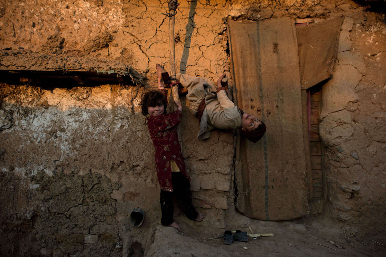 Feb. 9, 2014. Afghan children, whose family fled their home country to Pakistan, play outside their makeshift shelter in a slum on the outskirts of Islamabad.