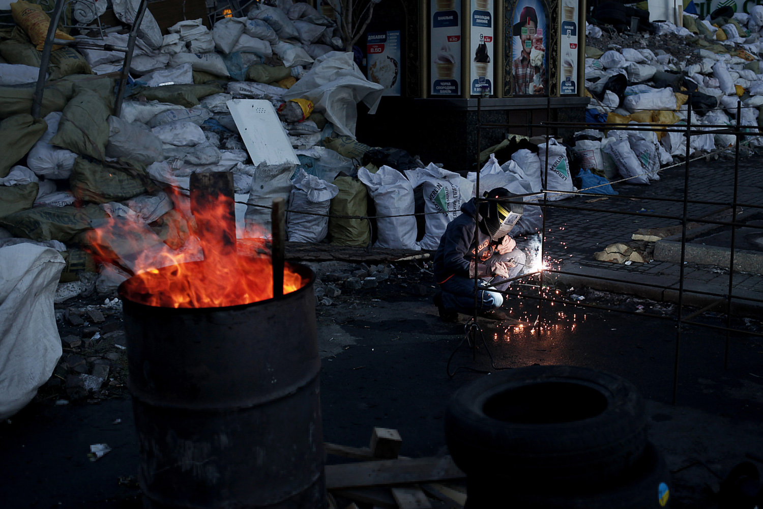 Feb. 5, 2014. An anti-government protester welds steel structures at a barricade in Independence Square.