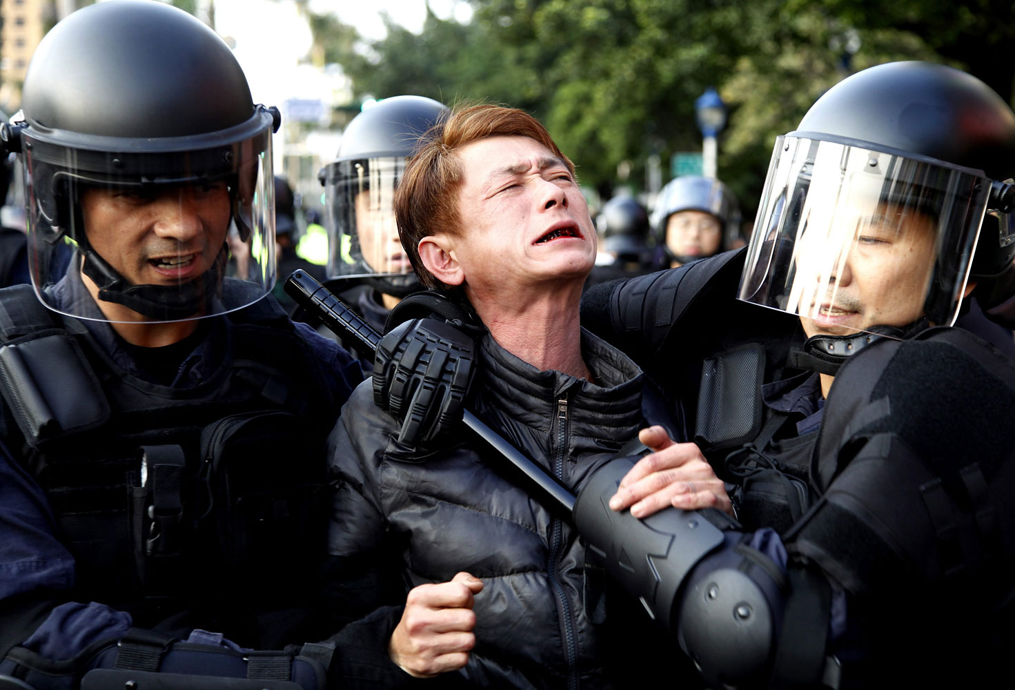 Riot police detain a protester near the Cabinet compound in Taipei, Taiwan, March 24, 2014.