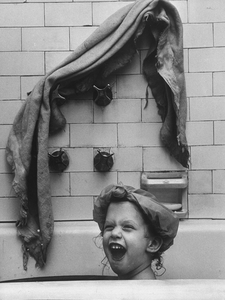 Daughter of LIFE photographer Martha Holmes, Anne Holmes Waxman, taking a bath with her blanket, 1959.