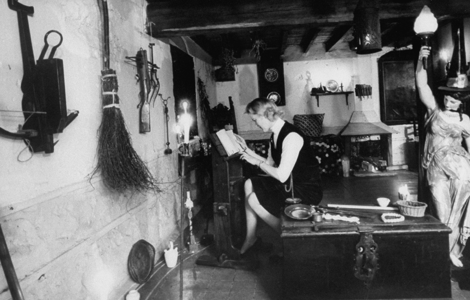 A witch studying in a museum, England, 1964.