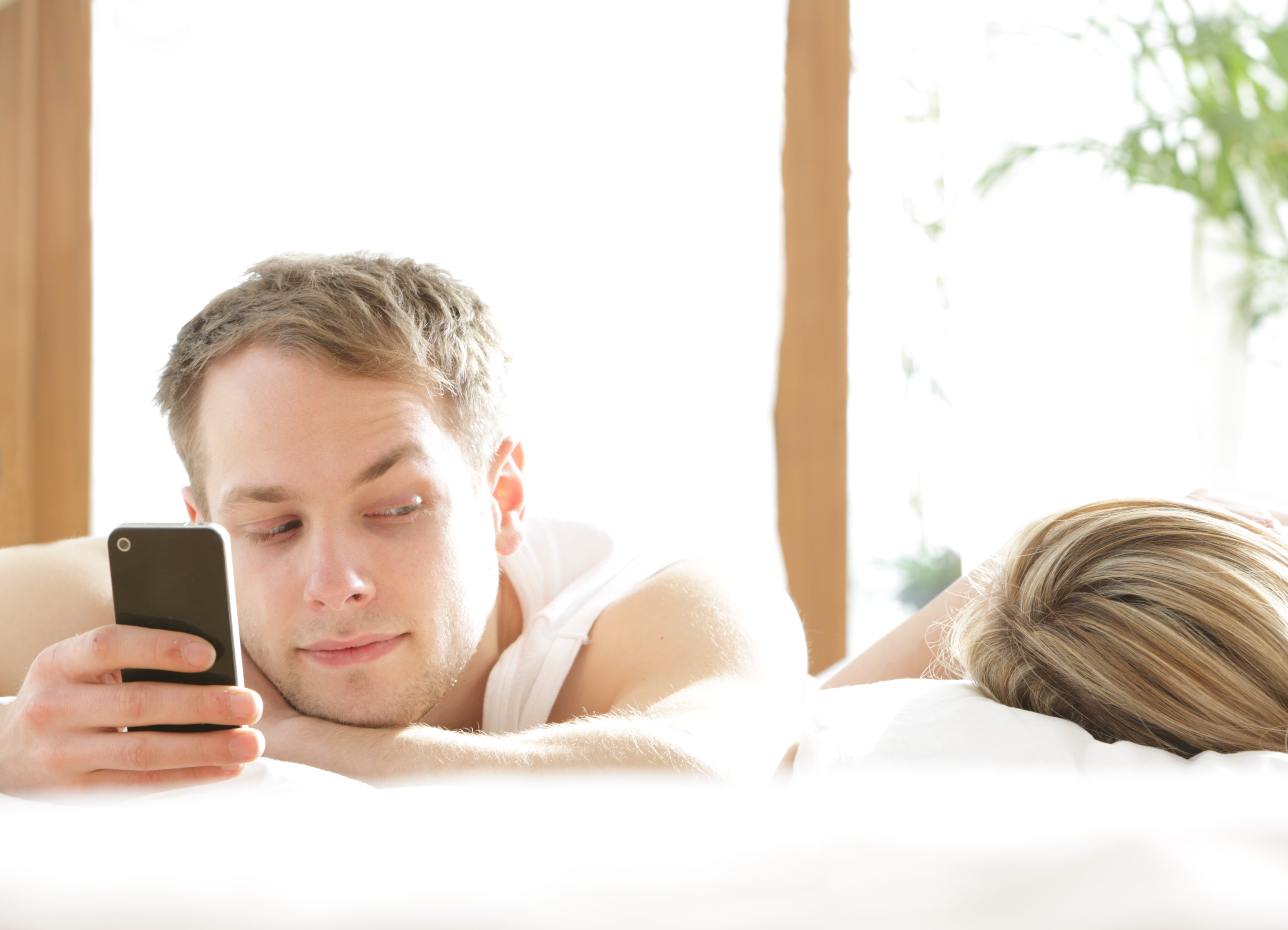 Couple in bed with smartphone