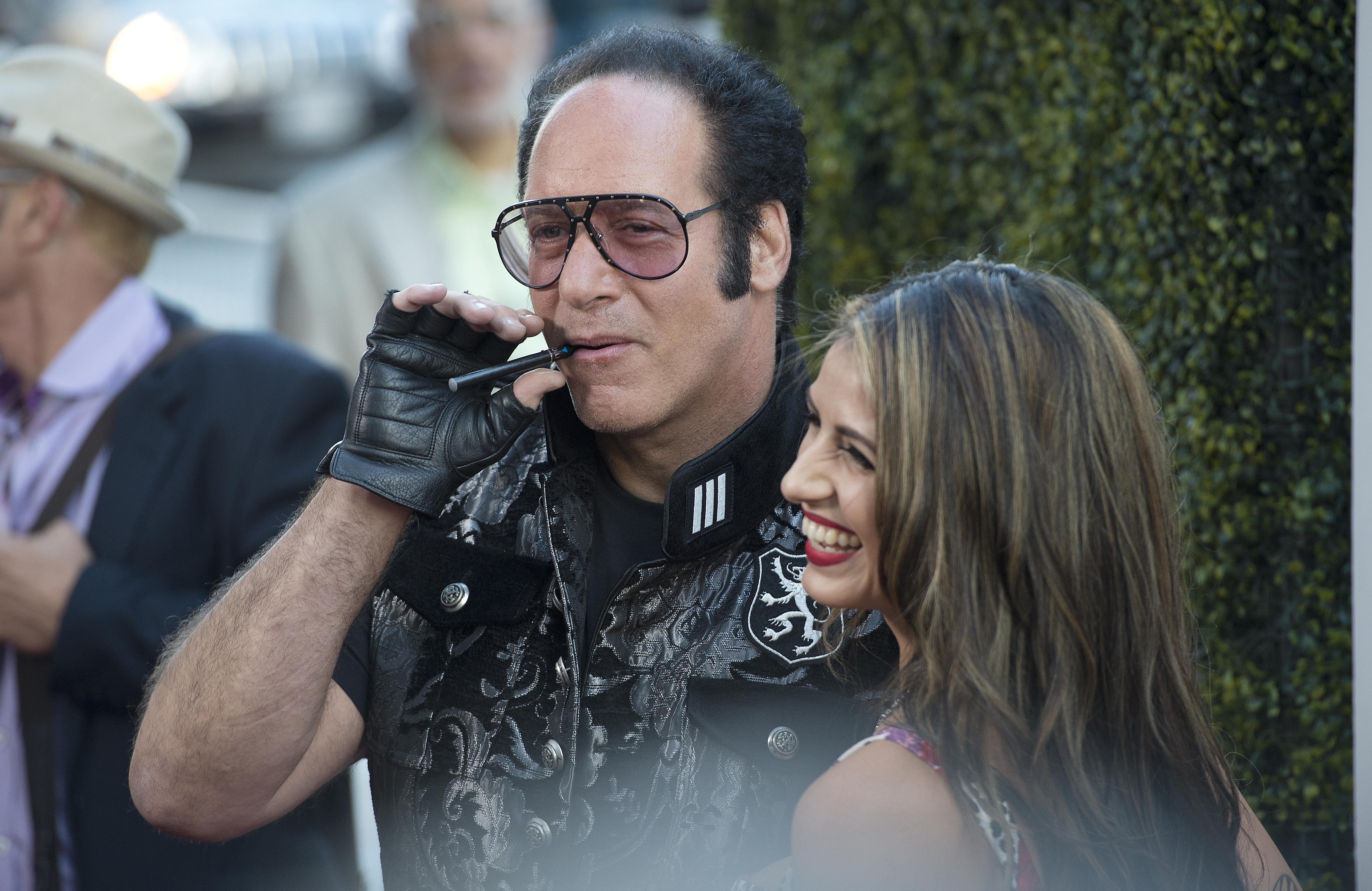 Cast member Andrew Dice Clay smokes an e-cigarette as he arrives with Valerie Vasquez for the premiere of the film 