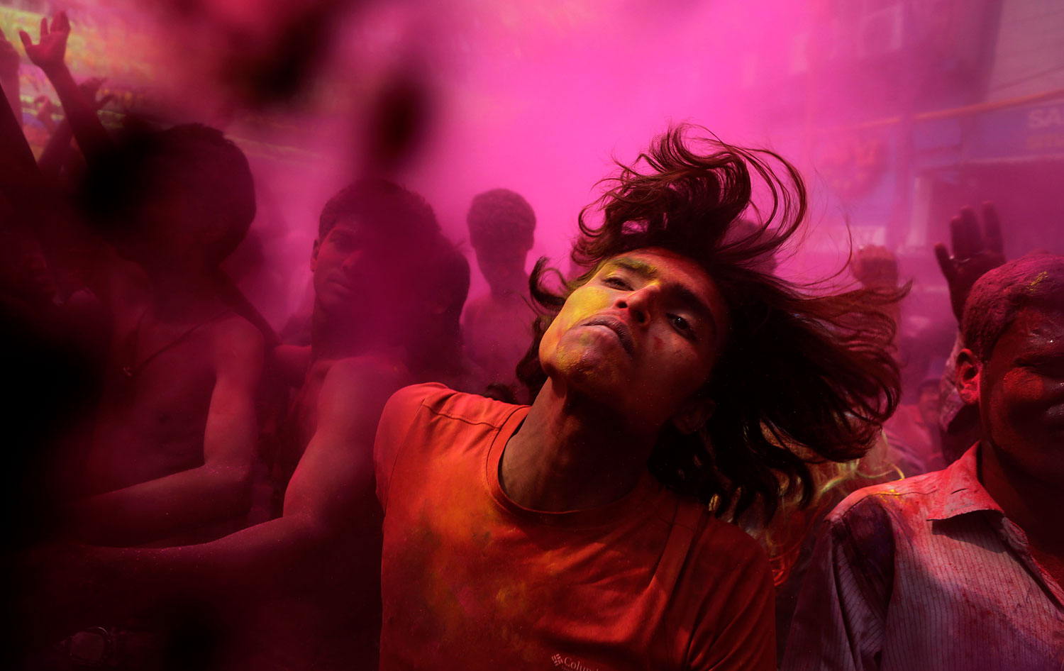 Indians, faces smeared with colored powder, dance during celebrations marking Holi, the Hindu festival of colors, in Gauhati, India, March 17, 2014.