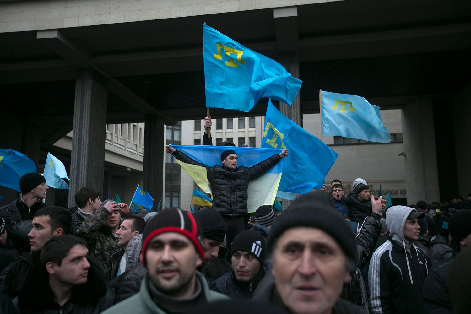 Crimean Tatars hold flags during rallies near the Crimean parliament building in Simferopol, Feb. 26, 2014.