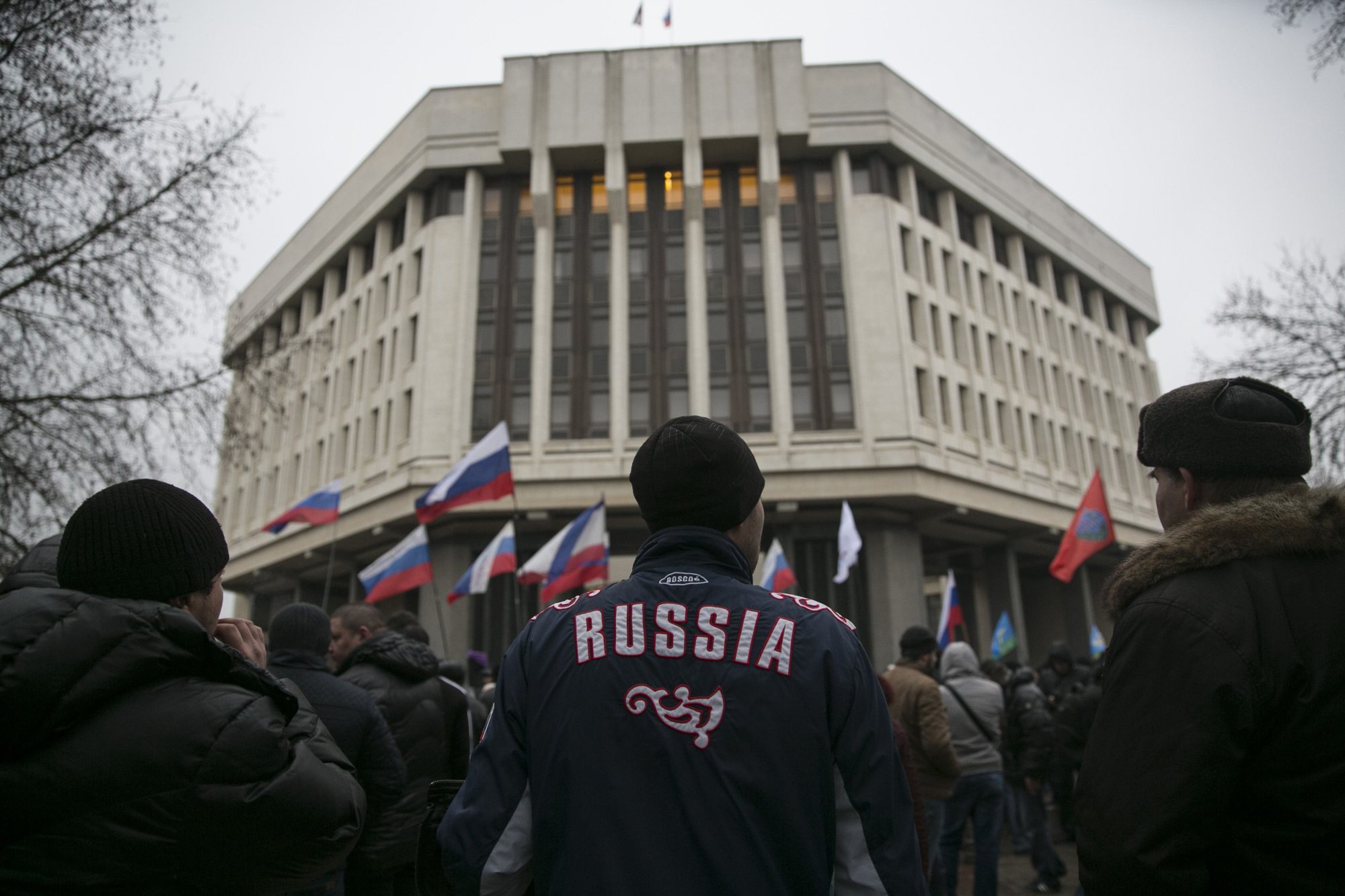 Men stand during a pro-Russian rally outside the Crimean parliament building in Simferopol, Feb. 27, 2014.