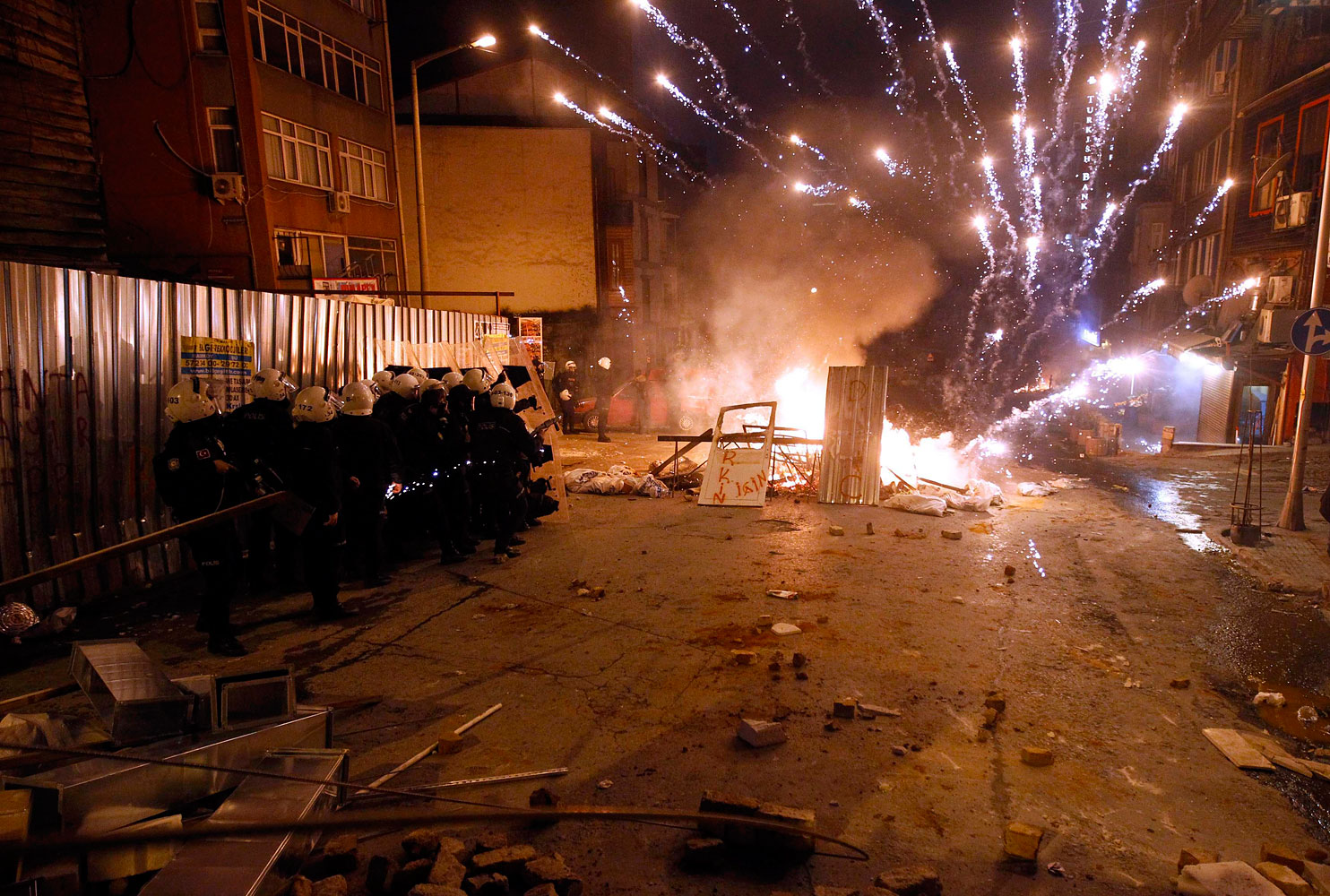Riot policemen shield themselves as fireworks thrown by anti-government protesters explode near central Taksim square in Istanbul March 12, 2014.