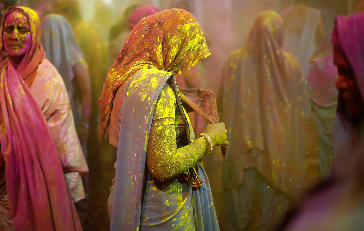 Women, who are former scavengers, are daubed in colours as they take part in Holi celebrations organised by non-governmental organisation Sulabh International at a widow's ashram in Vrindavan in the northern Indian state of Uttar Pradesh, March 14, 2014.