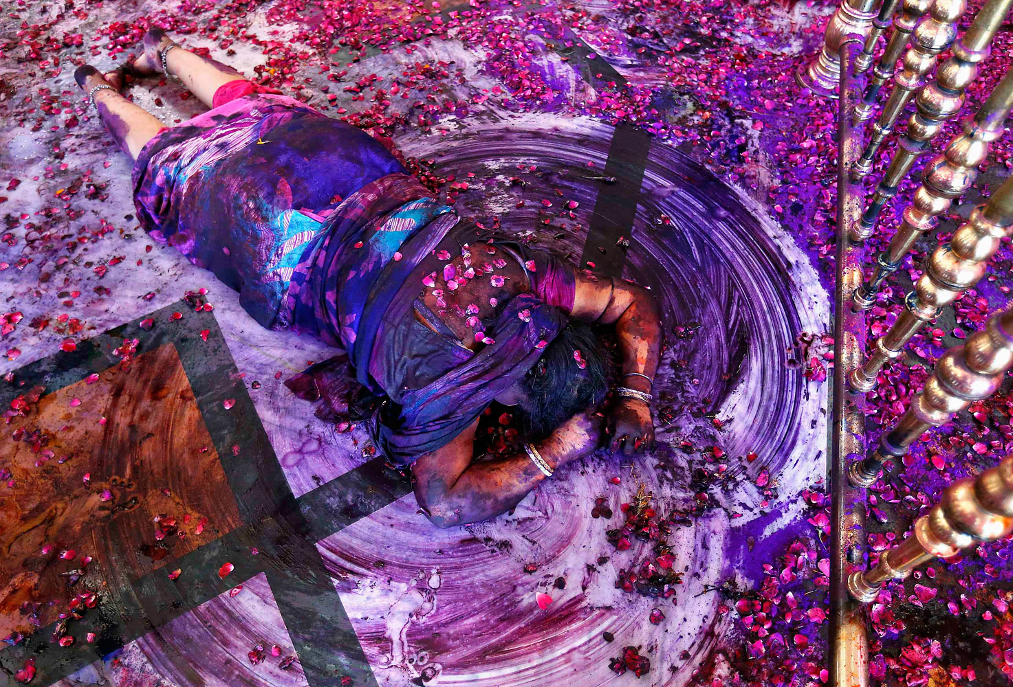 A Hindu woman prays while lying on the floor of a temple during Holi celebrations in the western Indian city of Ahmedabad, March 17, 2014.