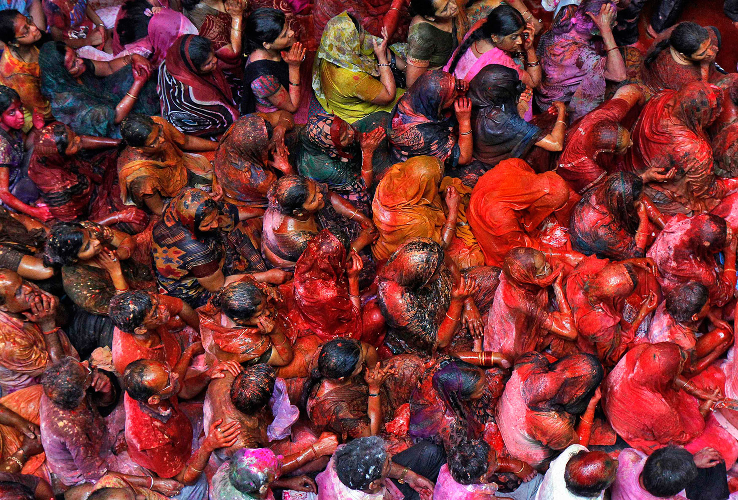 Hindu devotees daubed in colours sit as they sing hymns during Holi celebrations at Shamlal Ji temple in Kolkata, March 17, 2014.