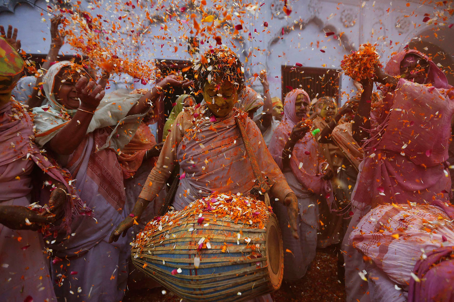 Widows dance as they throw flowers into the air during Holi celebrations organised by non-governmental organisation Sulabh International at a widows' ashram in Vrindavan in the northern Indian state of Uttar Pradesh, March 17, 2014.