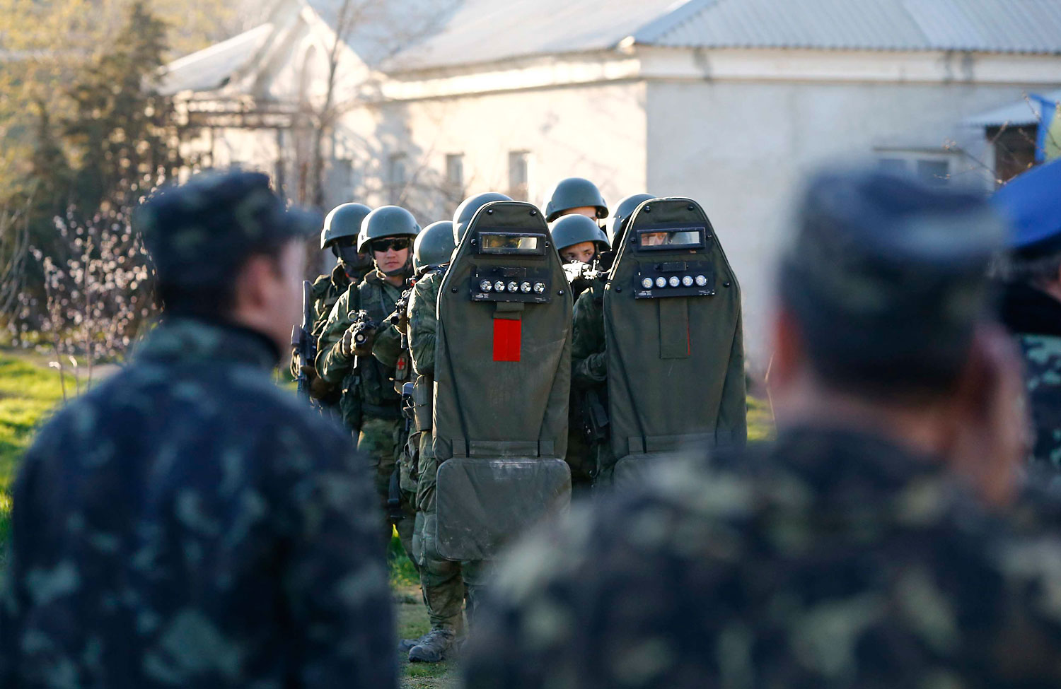 Armed men, believed to be Russian servicemen, stand guard, with Ukrainian servicemen seen in the foreground, at a military airbase, in the Crimean town of Belbek near Sevastopol March 22, 2014. (Shamil Zhumatov—Reuters)