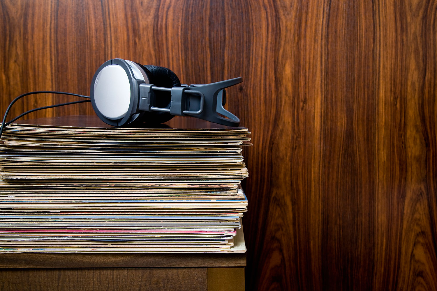 Headphones laying on stack of vinyl records