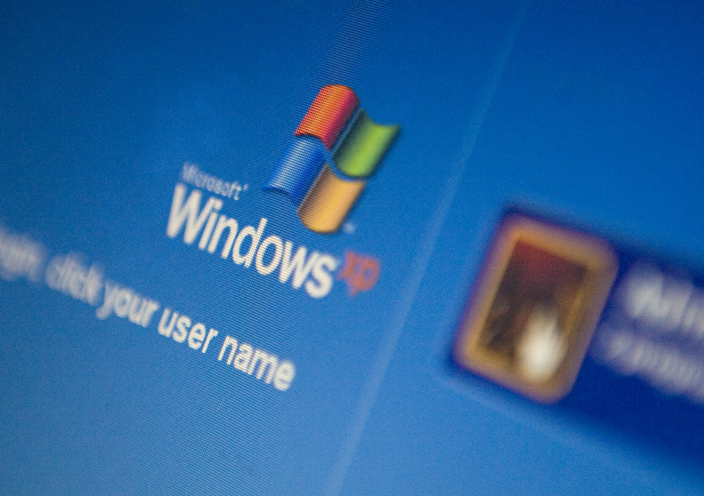 The Microsoft Windows XP log-in screen is displayed on a lap
