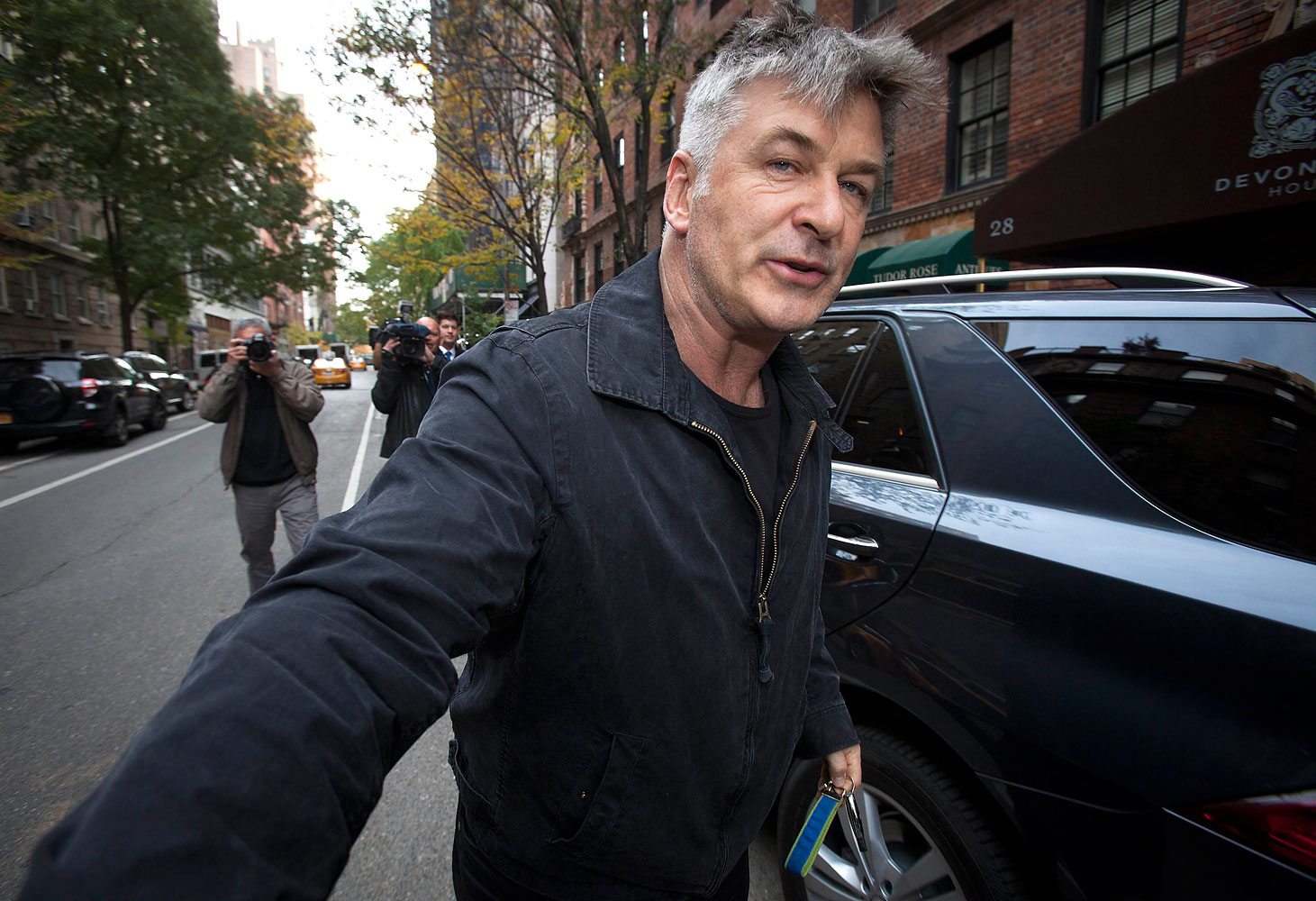 Actor Alec Baldwin shoves a photographer and tells him to move out of his way after he arrived in his SUV at the building where he lives in New York