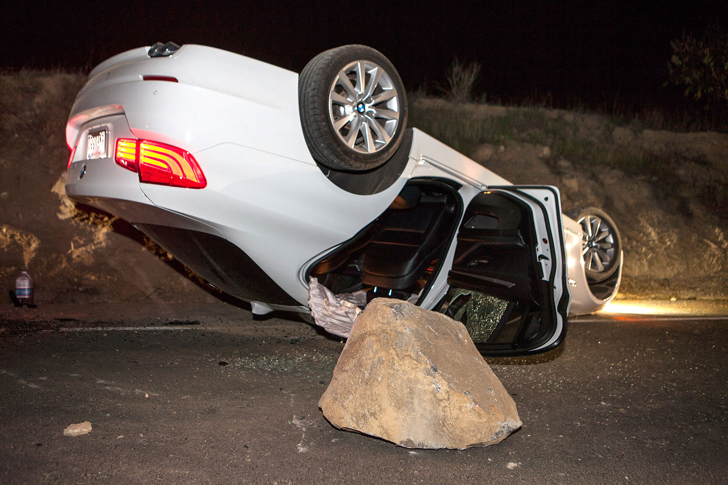 A car sits overturned on a highway in the Carbon Canyon area of Brea, Calif., March 28, 2014, after hitting a rock slide caused by an earthquake. (Kevin Warn—AP)